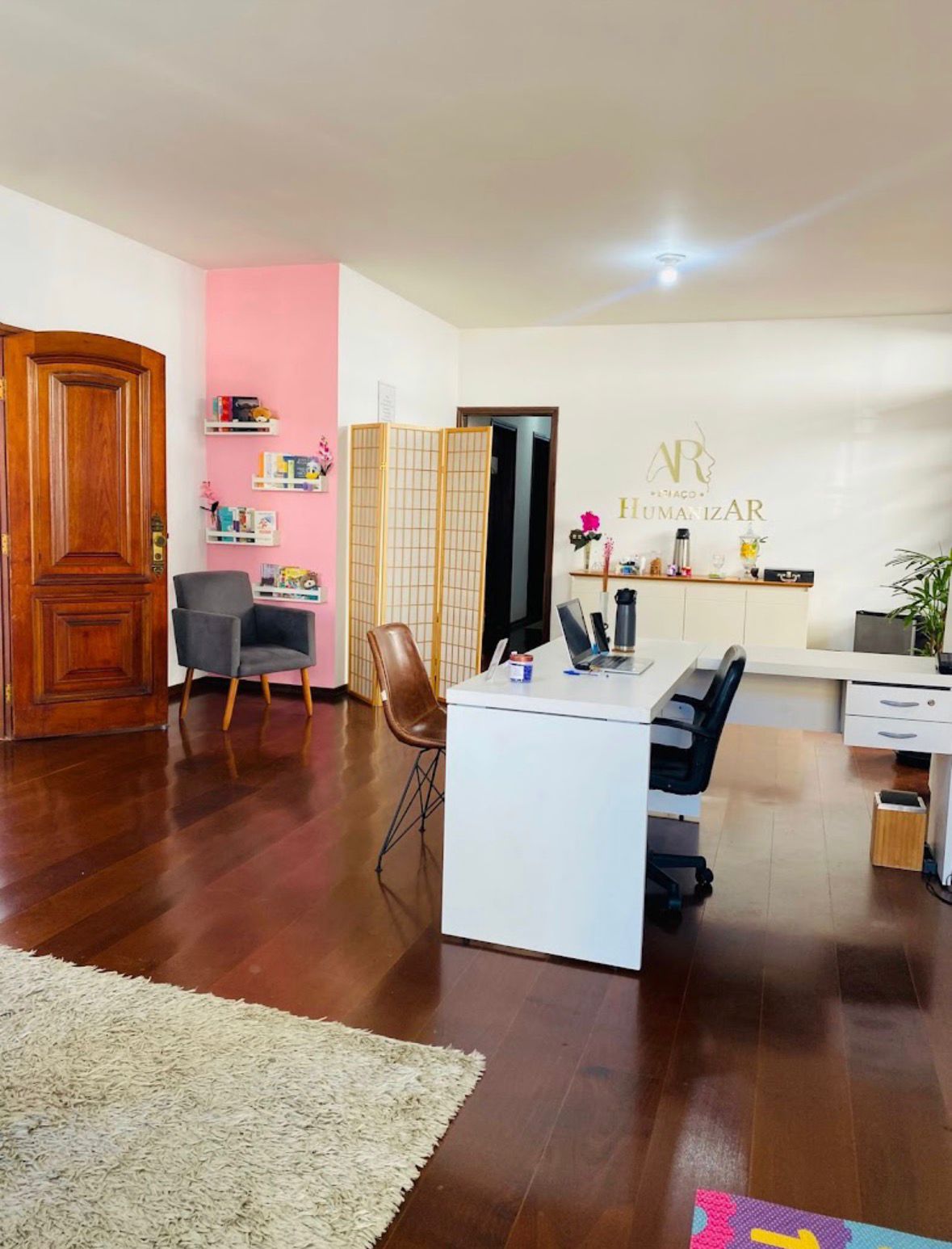 Sala de atendimento ampla com escrivaninha e poltrona