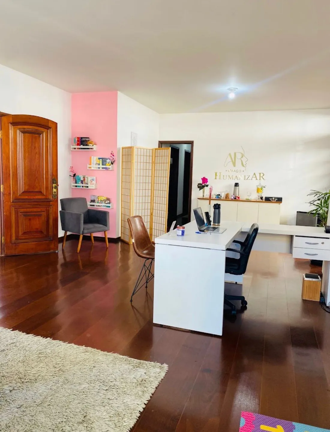 Sala de atendimento ampla com escrivaninha e poltrona